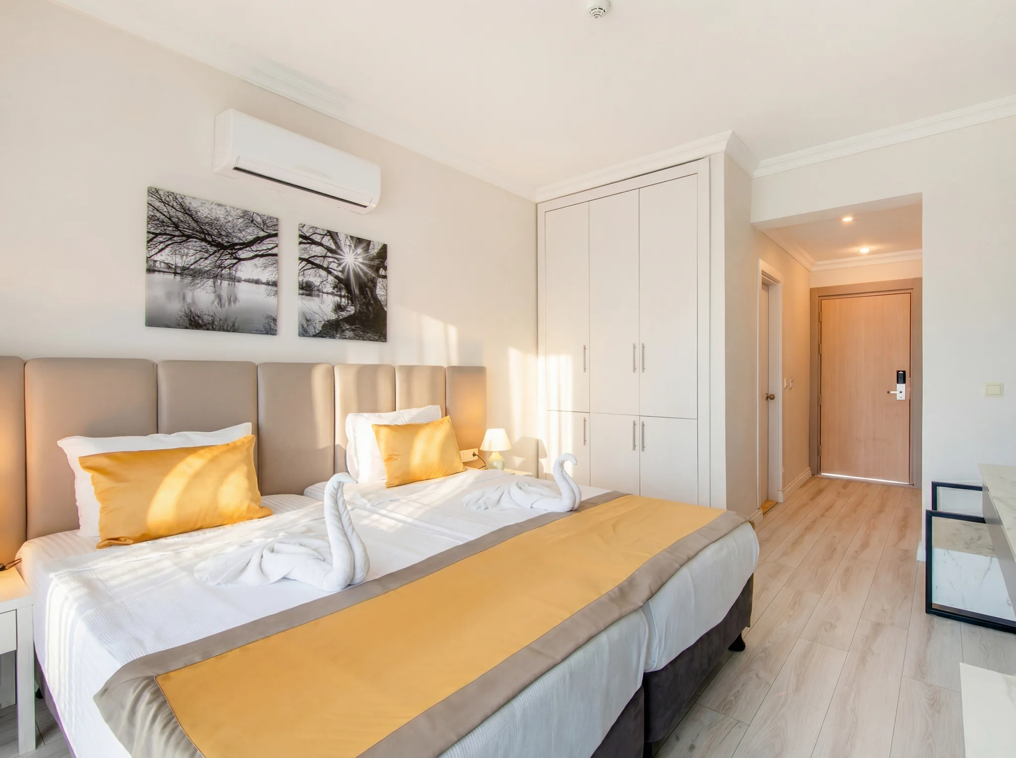 Betten, Kleiderschrank und Eingang im Deluxe Zimmer